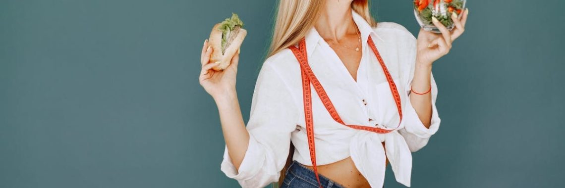 Woman enjoys healthy lifestyle with fresh salad and sandwich, promoting balanced eating.
